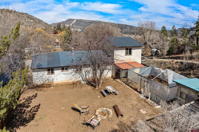 exterior space with an outdoor structure, a mountain view, and metal roof