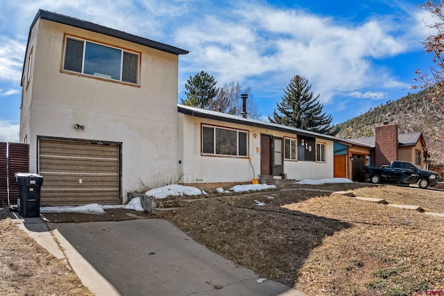 view of front of house with stucco siding, driveway, and a garage