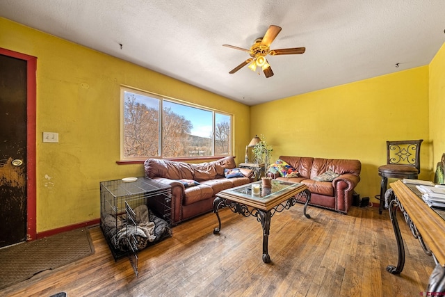 living area with a textured ceiling, ceiling fan, and hardwood / wood-style flooring