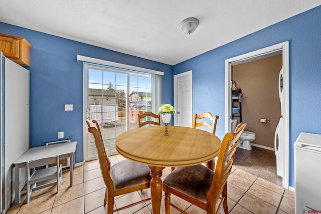 dining space with washer / dryer, baseboards, and a textured wall