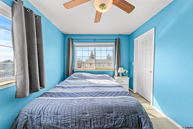 carpeted bedroom with baseboards and ceiling fan