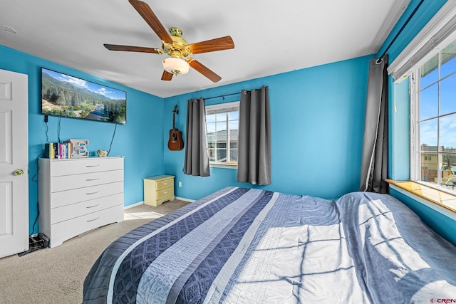 carpeted bedroom featuring baseboards and a ceiling fan