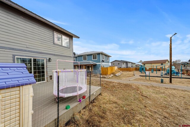 view of yard with a residential view, a playground, central AC unit, and fence