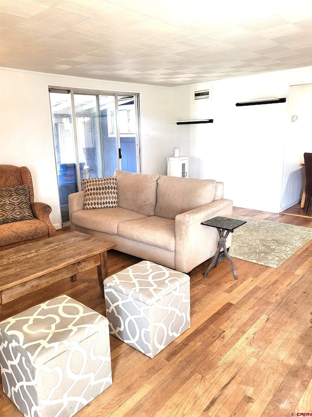 living room with hardwood / wood-style floors and visible vents