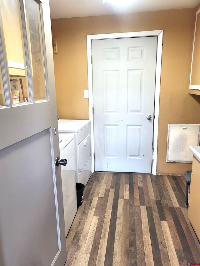 clothes washing area with dark wood-style floors, laundry area, and independent washer and dryer