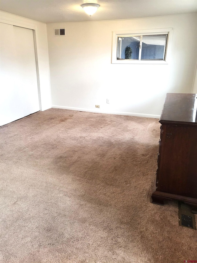 unfurnished bedroom featuring carpet and visible vents