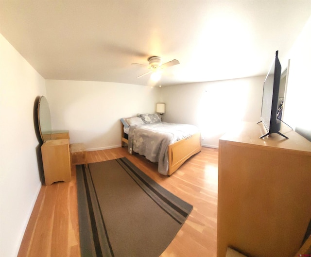 bedroom with light wood-style flooring, a ceiling fan, and baseboards