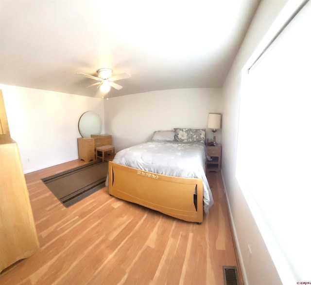 bedroom featuring visible vents, ceiling fan, baseboards, and light wood-style floors