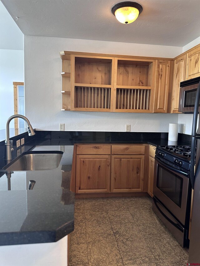 530 Redcliff Cir Unit F-203, Ridgway, CO 81432 - kitchen featuring dark stone countertops, open shelves, granite finish floor, a sink, and stainless steel appliances