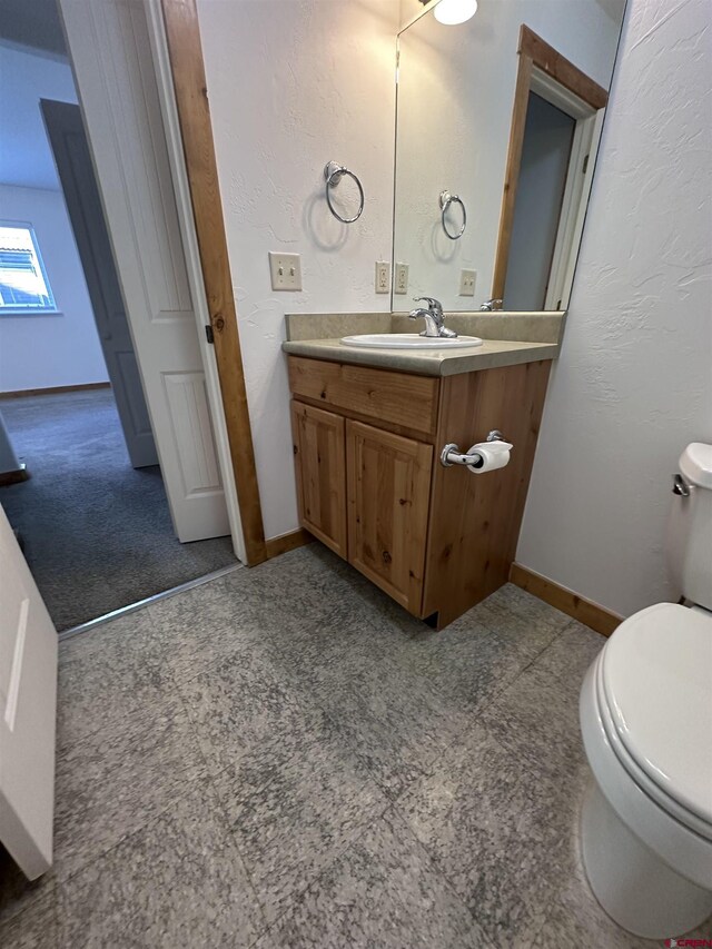 530 Redcliff Cir Unit F-203, Ridgway, CO 81432 - bathroom with toilet, vanity, baseboards, and a textured wall