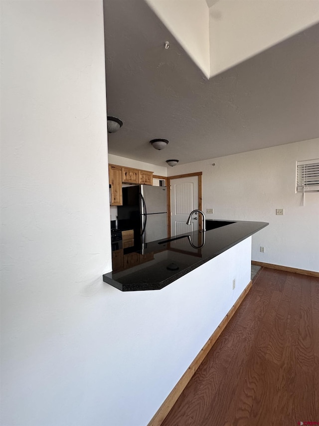 530 Redcliff Cir Unit F-203, Ridgway, CO 81432 - kitchen featuring dark countertops, baseboards, brown cabinets, freestanding refrigerator, and dark wood-style floors