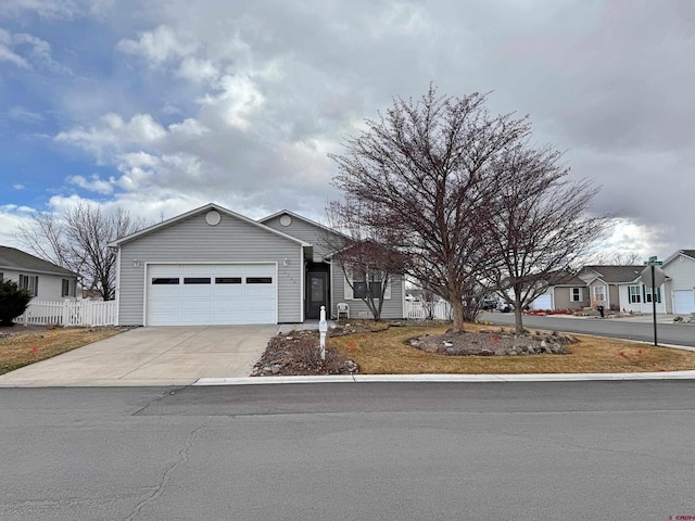 single story home with driveway, a garage, and fence