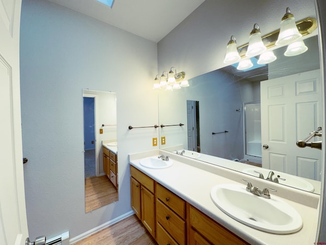 bathroom with double vanity, walk in shower, and a sink