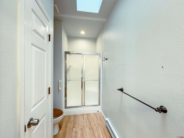 bathroom featuring a skylight, toilet, visible vents, and a stall shower