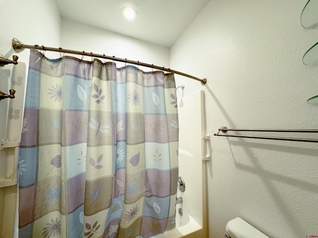 bathroom featuring shower / bath combination with curtain and toilet