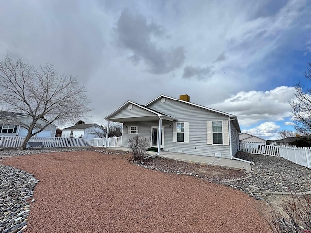 bungalow-style house with a patio area, a fenced backyard, and a chimney