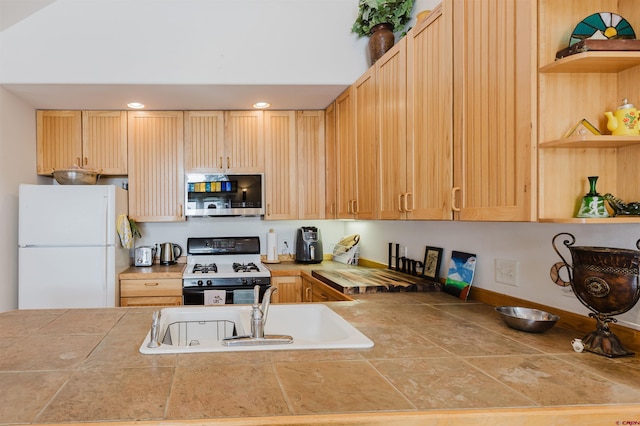 kitchen featuring open shelves, freestanding refrigerator, a sink, range with gas cooktop, and stainless steel microwave