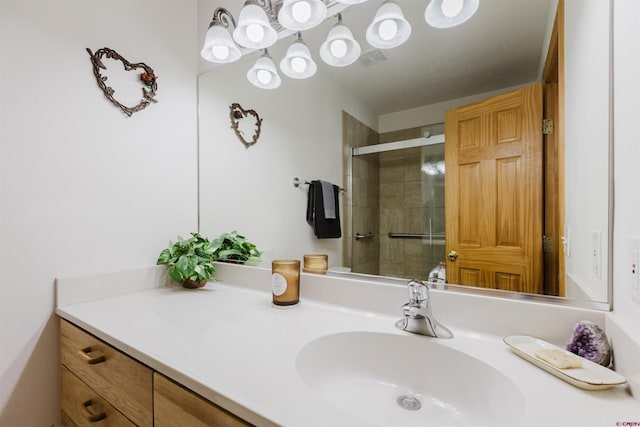 full bath with visible vents, tiled shower, and vanity