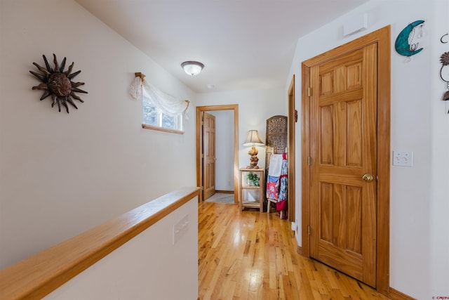 hallway with baseboards and light wood-style floors