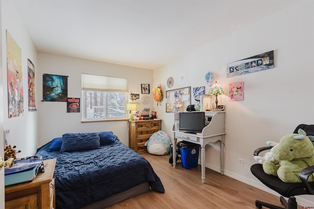 bedroom featuring baseboards and wood finished floors