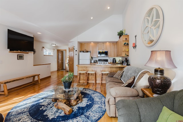 living area featuring recessed lighting, light wood-style floors, and high vaulted ceiling