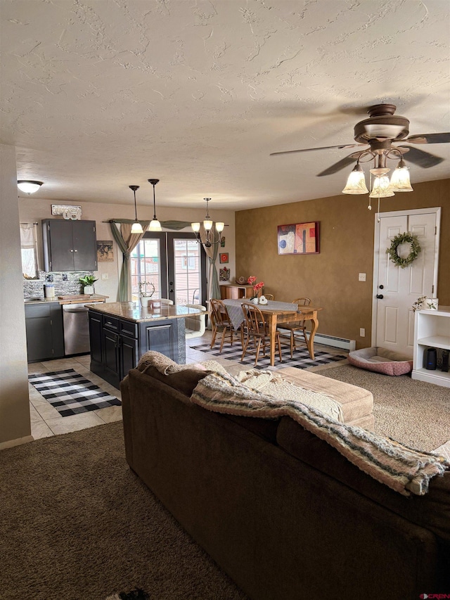 living area featuring ceiling fan with notable chandelier, french doors, and a textured ceiling