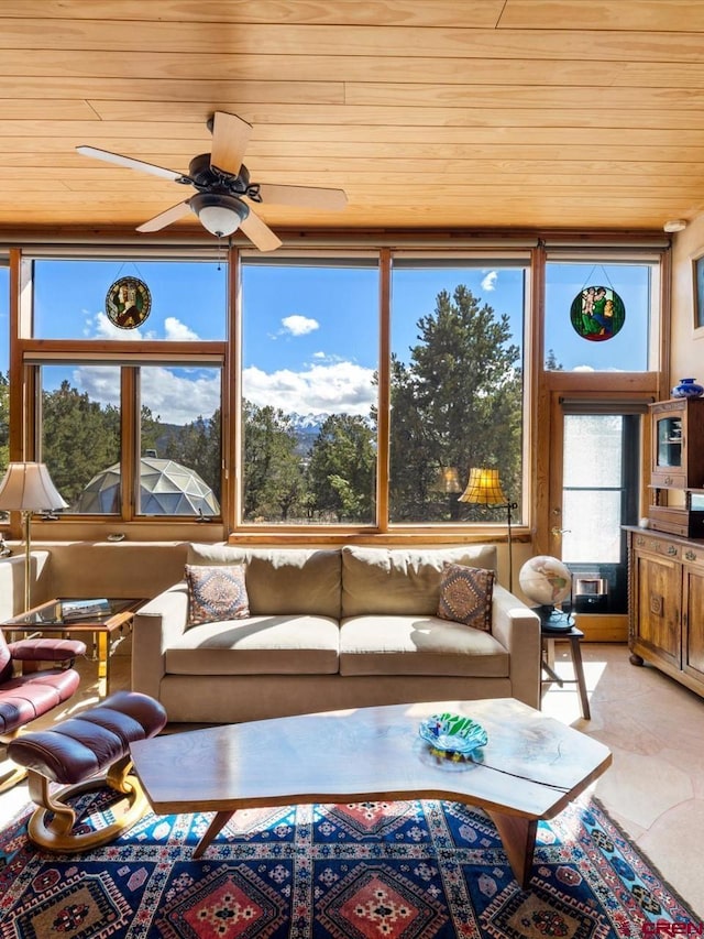 sunroom / solarium featuring wooden ceiling and a ceiling fan