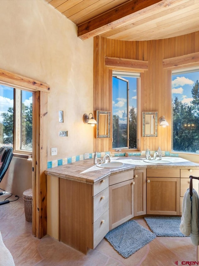 kitchen featuring a sink, beam ceiling, wood ceiling, and light countertops