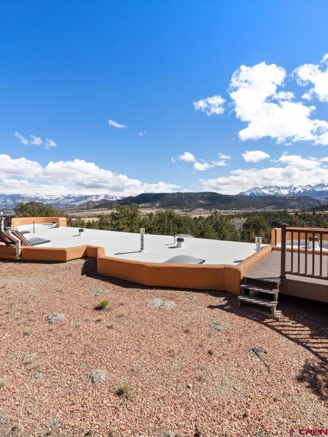 view of yard featuring a deck with mountain view