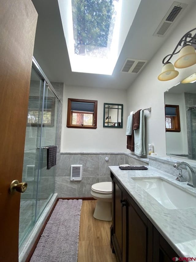 bathroom featuring tile walls, visible vents, and a shower stall