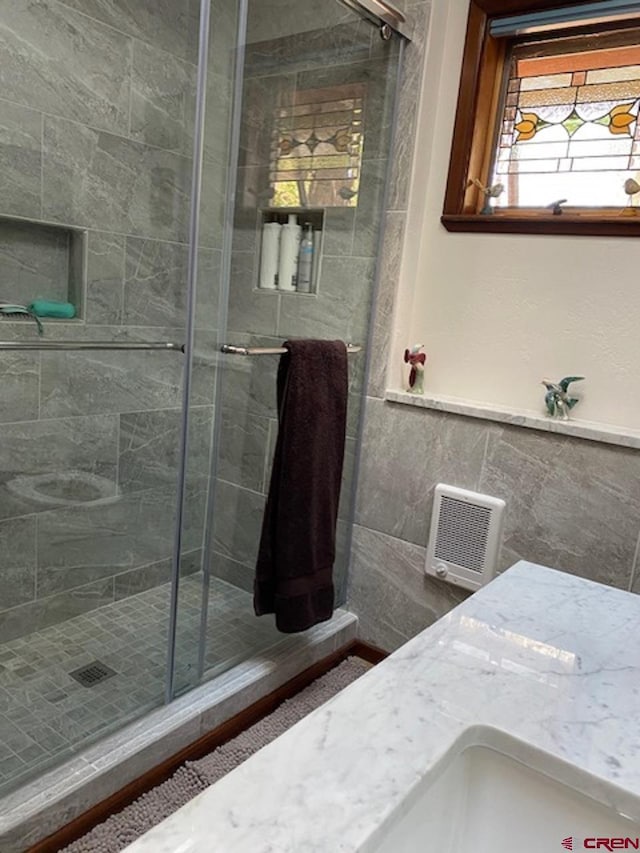 full bathroom featuring a stall shower and tile walls