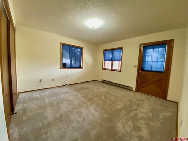 interior space featuring a baseboard radiator, a textured ceiling, and carpet