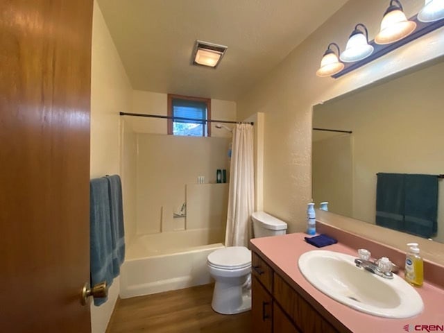 bathroom with visible vents, shower / bath combo with shower curtain, toilet, wood finished floors, and vanity