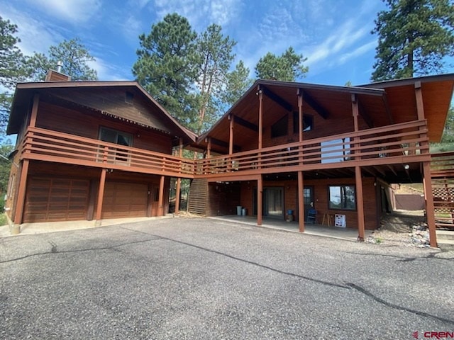 view of front of property with a garage, driveway, and a wooden deck