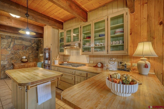 kitchen with wooden ceiling, stainless steel gas stovetop, under cabinet range hood, and butcher block countertops