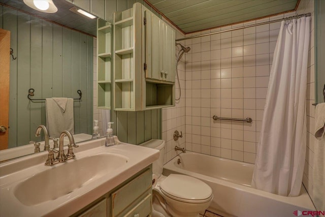 full bath featuring shower / bath combo with shower curtain, toilet, vanity, and wooden walls