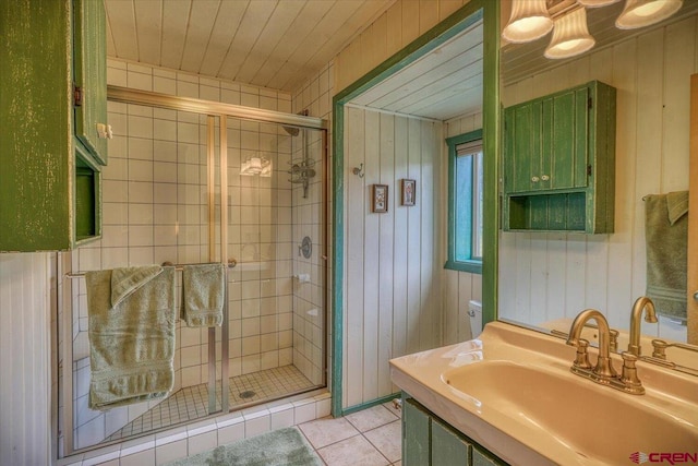 full bathroom featuring a shower stall, wooden ceiling, wood walls, and tile patterned floors