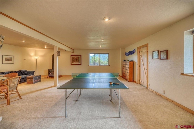 recreation room with baseboards, carpet, and a textured ceiling