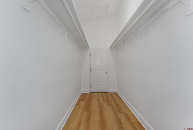 spacious closet with light wood-type flooring and attic access