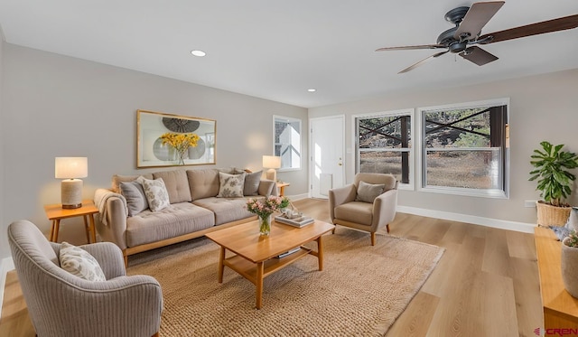 living area featuring plenty of natural light, light wood-style flooring, and baseboards