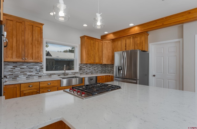 kitchen featuring a sink, stainless steel appliances, light stone counters, and decorative backsplash