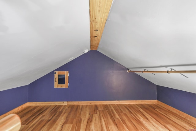 additional living space with lofted ceiling, wood finished floors, and baseboards