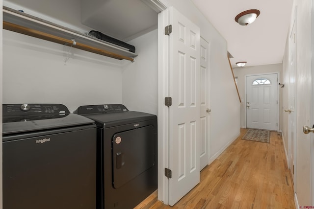 laundry area featuring baseboards, independent washer and dryer, light wood-style flooring, and laundry area