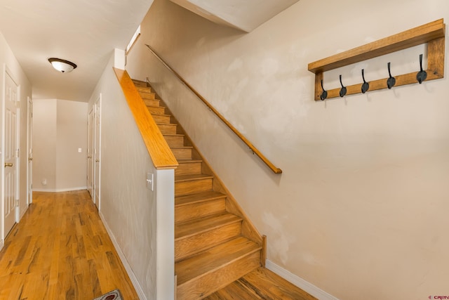 staircase with baseboards and wood finished floors