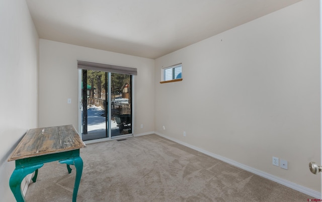 spare room with carpet flooring, visible vents, and baseboards