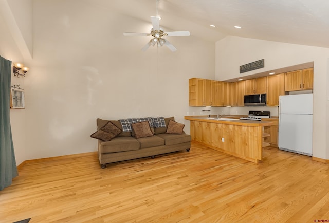 kitchen featuring white appliances, light wood-style flooring, a peninsula, and open floor plan