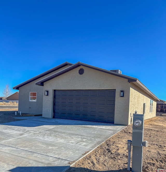 3601 Tinker Dr, Aztec, NM 87410 - view of side of home with stucco siding, a garage, and concrete driveway