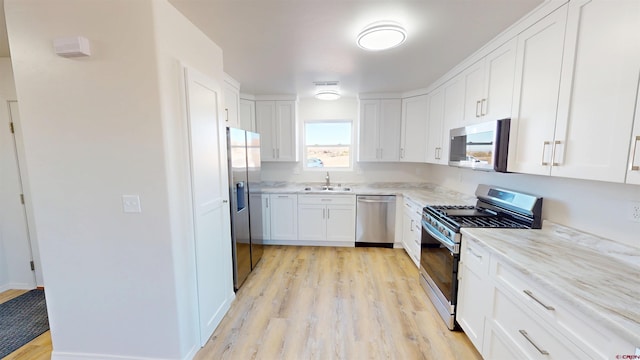 3601 Tinker Dr, Aztec, NM 87410 - kitchen featuring a sink, light wood-style flooring, appliances with stainless steel finishes, and white cabinets