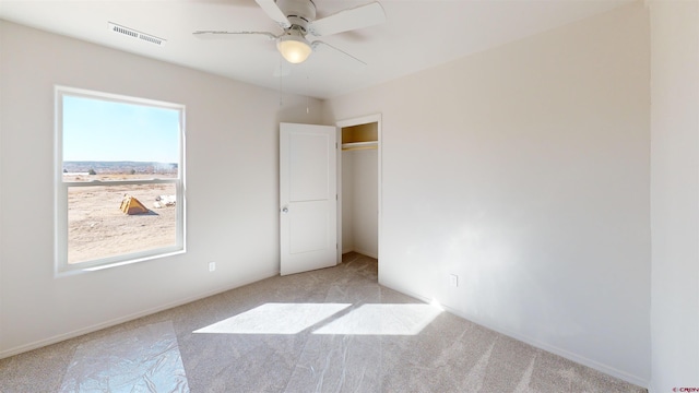 3601 Tinker Dr, Aztec, NM 87410 - unfurnished bedroom featuring visible vents, baseboards, light colored carpet, a closet, and a ceiling fan
