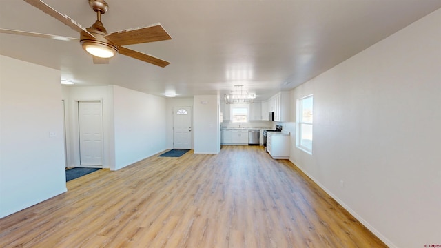 3601 Tinker Dr, Aztec, NM 87410 - unfurnished living room with ceiling fan with notable chandelier, baseboards, and light wood finished floors